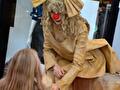 Clowntje Nosy, living statue op een grote koffer